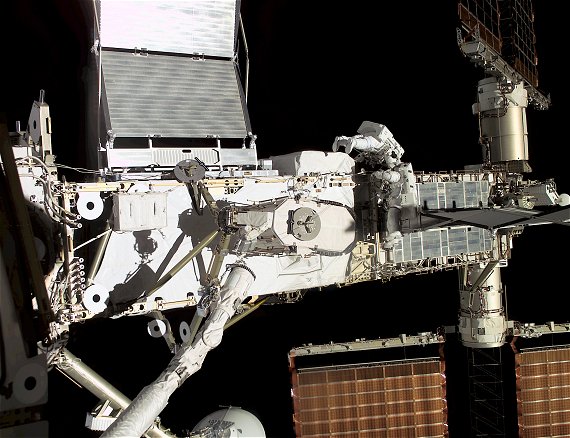 Tv astronauter under en rymdpromenad vid masten till solpanelerna